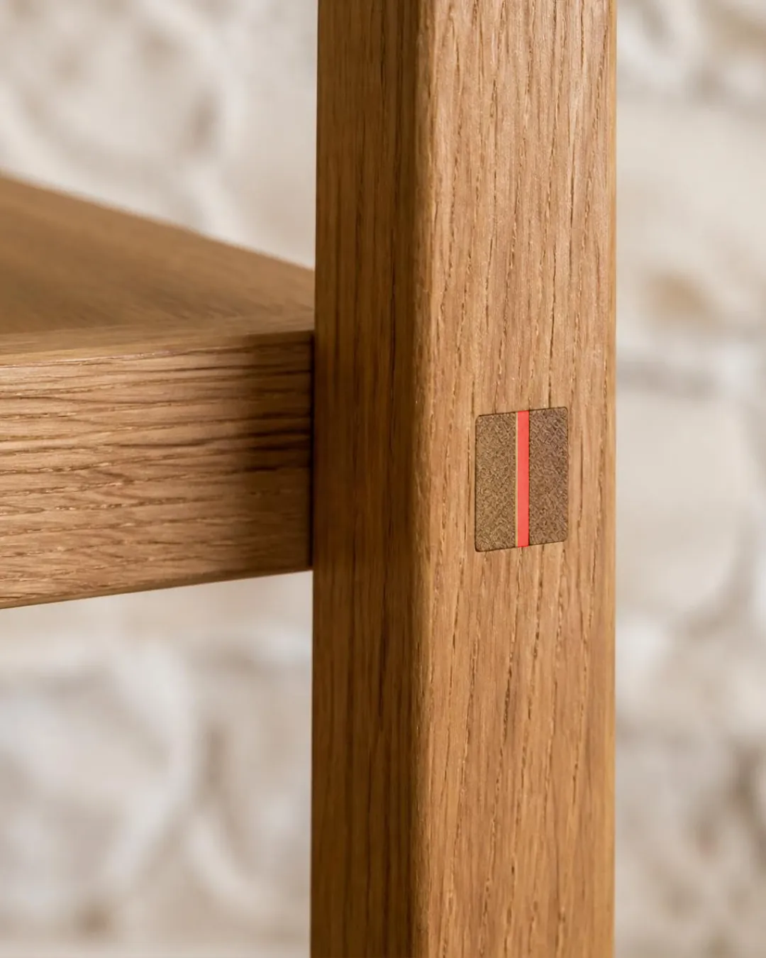 An oak chair leg with a through-tenon; the wedge in the joint is stained red.