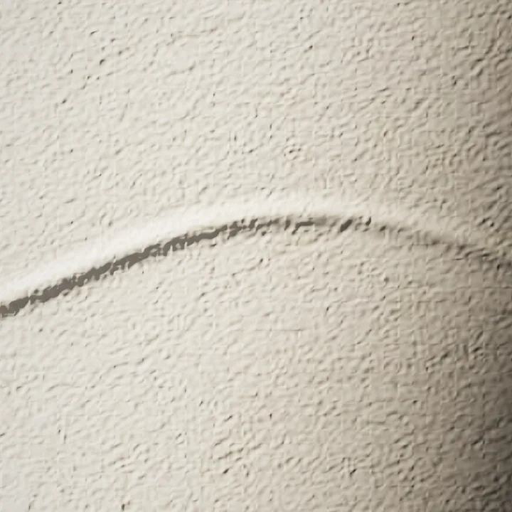 The tide line blind-embossed into cotton paper, caught by a low light.