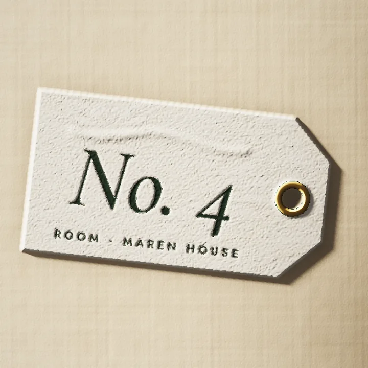 Close-up of the No. 4 room tag and its brass eyelet.