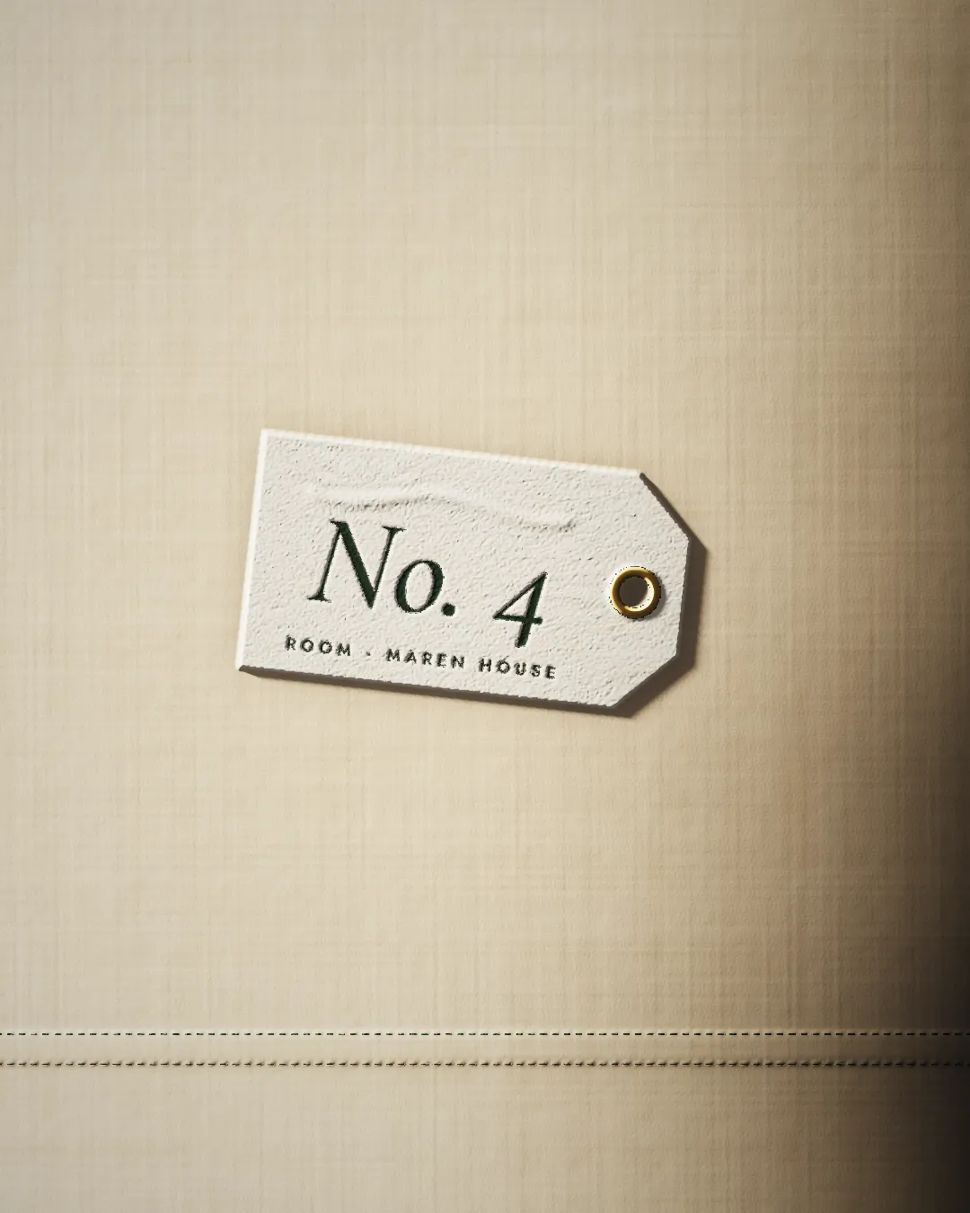 A cotton room tag reading No. 4, Room, Maren House, with a brass eyelet.
